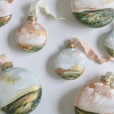 some ornaments are sitting on the table together and one is painted with watercolors