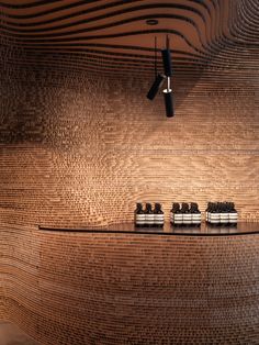 a shelf with jars and lights on it in front of a wall made of wood