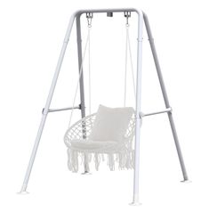 a white swing chair with fringes on the seat and back legs, in front of a