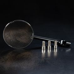 a magnifying glass sitting on top of a table next to some screws