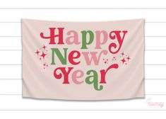 a pink wall hanging with the words happy new year written in red and green on it