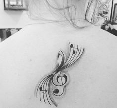 the back of a woman's shoulder with musical notes and trebles on it