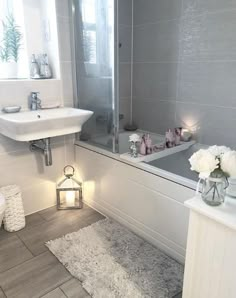 a bath room with a sink and a bath tub next to a mirror on the wall