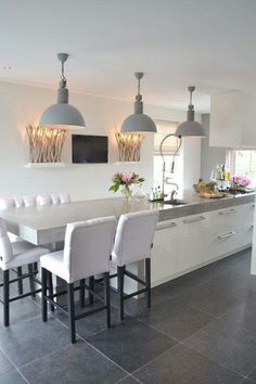 a kitchen with white chairs and an island