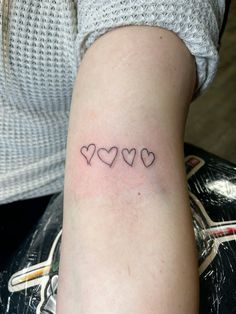 a woman's arm with three small hearts on the left side of her arm