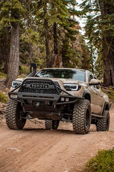 the toyota truck is driving on a dirt road