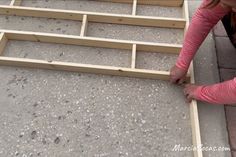 a woman is working on the floor with wooden boards and plywood planks in front of her