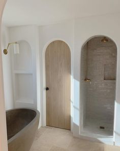 a bathroom with an oval bathtub and two arched doorways in the wall next to it