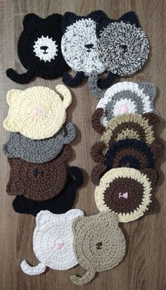 several crocheted animal coasters on a wooden surface