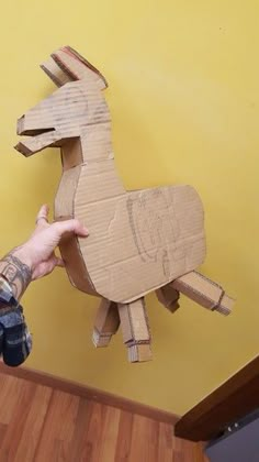 a person is holding up a cardboard horse