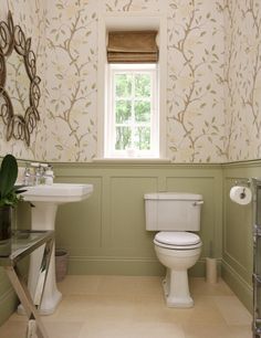 a bathroom with a toilet, sink and mirror in it's centerpieces