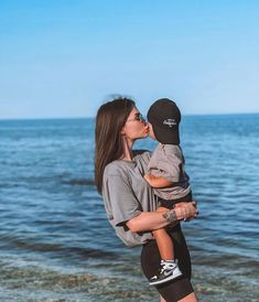 a woman holding a child on the beach