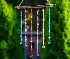 a wind chime hanging from a tree branch with colorful beads attached to the strings