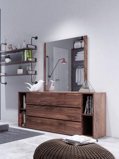 a living room with a large mirror on the wall next to a dresser and ottoman