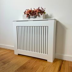 a white radiator sitting on top of a wooden floor next to a wall