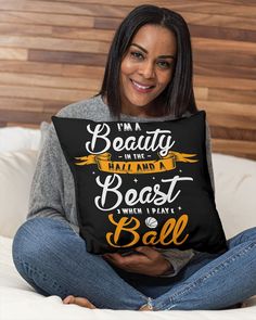 a woman sitting on top of a bed holding a pillow that says i'm a beauty