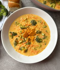 a white bowl filled with broccoli and cheese soup