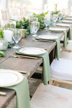 the table is set with plates and place settings for guests to sit down at it