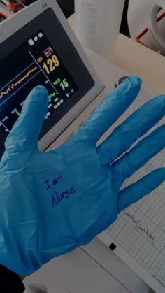 a gloved hand with writing on it in front of a computer screen that reads i am nurse