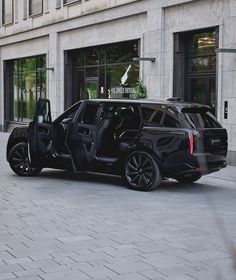 a black suv with its door open on the street