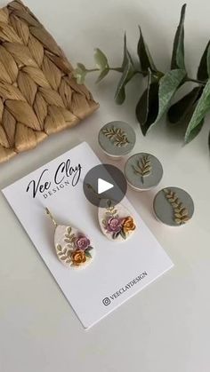 the earrings are on display next to some leaves and other things in front of it