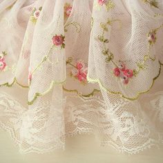 there is a white dress with pink flowers on it