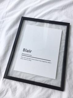 there is a black frame with a white sheet underneath it that has the word blai on it