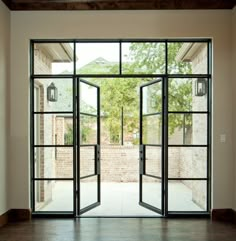 an open glass door leading to a brick building