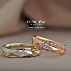 two gold wedding rings with diamonds on them are shown in front of a beige background