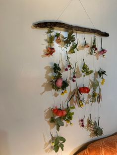 an arrangement of flowers hanging on a wall next to a bed with a wooden headboard