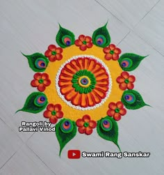 an intricate design on the floor with green leaves and red flowers in the center,