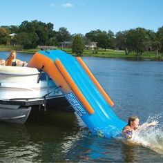 a child slides down the side of a boat into water with an inflatable slide attached to it