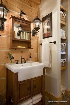 a bathroom with a sink, mirror and towel rack on the wall next to it