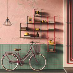 a bicycle parked in front of a pink wall with shelves on it and a lamp hanging from the ceiling