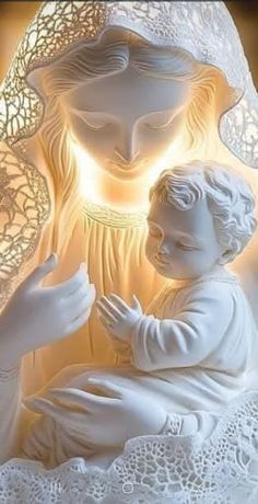 a statue of the virgin mary holding a baby jesus in her arms with light coming from behind it