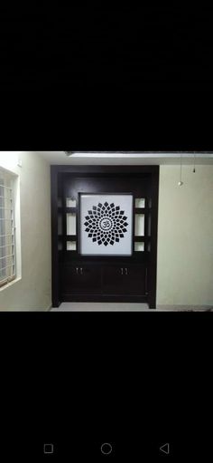 an empty room with a black and white flower on the wall in front of it