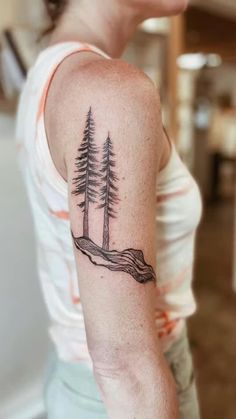 a woman with a tattoo on her arm and some trees in the middle of it