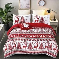 a red and white bed in a room with christmas decorations on the comforter set