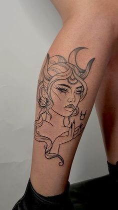 a woman's leg with a tattoo on it that has an image of a demon