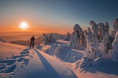 a man standing on top of a snow covered slope