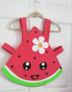 a watermelon bib hanging on a door with a flower in the center