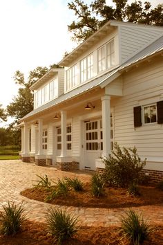 a white house with black shutters and brick walkway