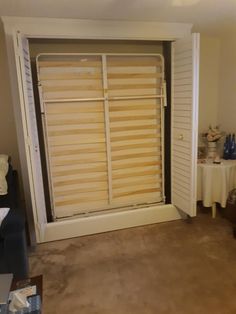 a living room with a sliding door that has blinds on it's sides, and a table in the background