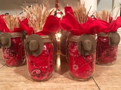 four mason jars filled with red and gold items