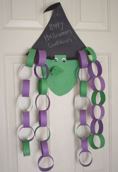 a door decorated with purple and green paper chains, a witch's hat on top