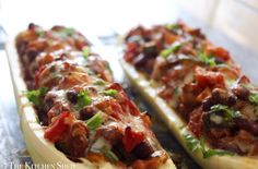 two long slices of bread with meat and vegetables on them, sitting on a table