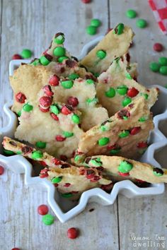 a white bowl filled with cookies and sprinkles on top of a wooden table