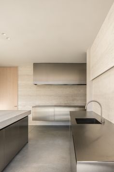 an empty kitchen with stainless steel appliances and counter tops