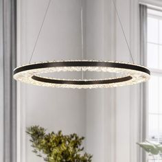 a circular chandelier hanging from the ceiling in a room with white walls and windows