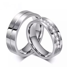 two white gold wedding rings with diamonds on each side and the word vox written in red